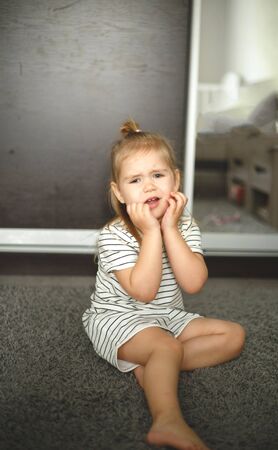 Little cute blonde blue-eyed girl is naughty.の写真素材