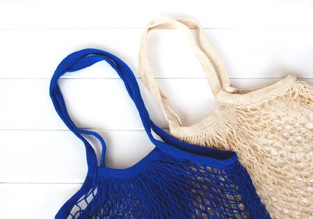 Empty blue and beige net bags on wooden background.の写真素材