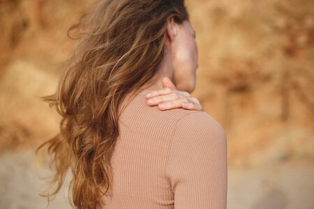 woman in beige posing on the beach. hands closeup.の写真素材