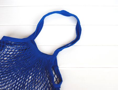 Empty blue net bag on wooden background.の写真素材