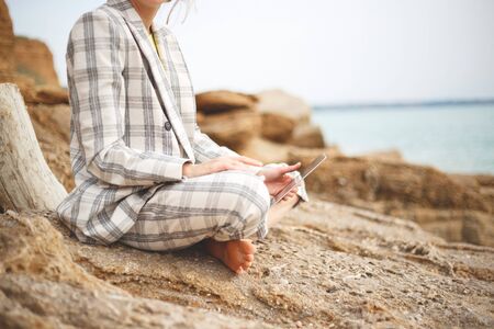 girl with a laptop by the sea. remote work concept.の写真素材