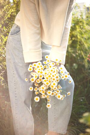 woman with a bouquet of daisies in an eco friendly net bag.の写真素材