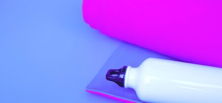 Bright purple yoga mat and bottle of water. flat layの写真素材