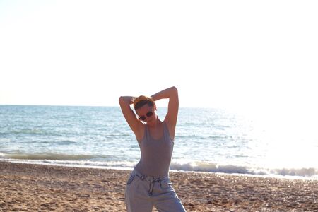 happy woman dancing barefoot on the sand by the sea.の写真素材