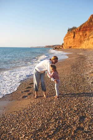 mom and daughter are playing on the sandy beach.の写真素材