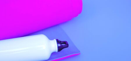 Bright purple yoga mat and bottle of water. flat layの写真素材