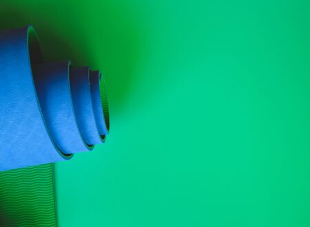 Bright blue yoga mat on a green background. flat layの写真素材