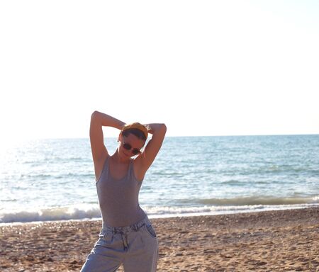happy woman dancing barefoot on the sand by the sea.の写真素材