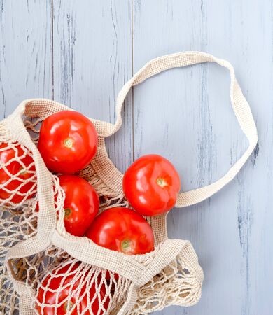 Package-free food shopping. Eco friendly natural bag with organic fruits and tomatoes. Zero waste concept.の写真素材