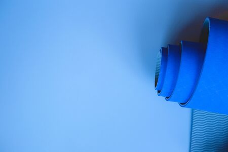 Bright blue yoga mat on a gray background. flat layの写真素材