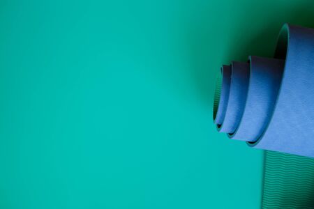 Bright blue yoga mat on a green background. flat layの写真素材