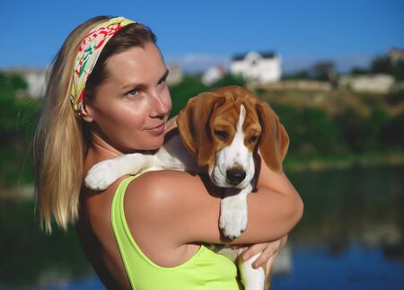 portrait of a young woman with a beagle puppy in her arms.の写真素材
