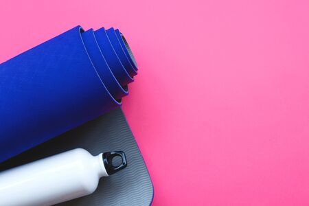Bright blue yoga mat on a pink background.の写真素材
