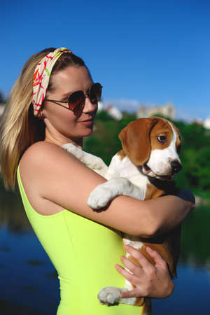 portrait of a young woman with a beagle puppy in her arms.の写真素材