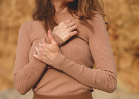 woman in beige posing on the beach. hands closeup.の写真素材