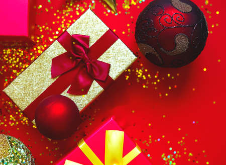 gift boxes with bows and Christmas toys on a red-gold background.