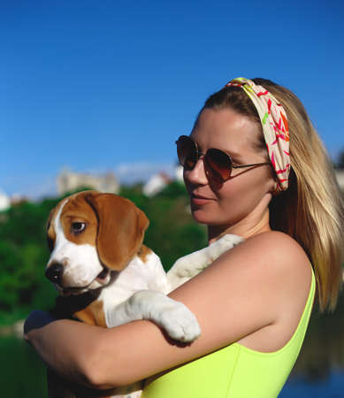 portrait of a young woman with a beagle puppy in her arms.の写真素材
