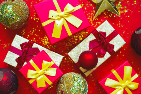 gift boxes with bows and Christmas toys on a red-gold background.の写真素材