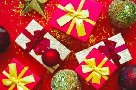 gift boxes with bows and Christmas toys on a red-gold background.の写真素材