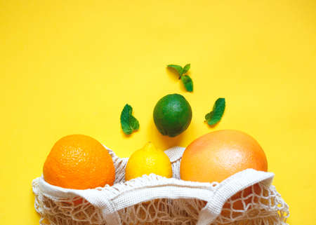 juicy ripe citrus fruits in an eco-friendly shopping bag.の写真素材