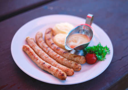 dish with bavarian sausages and mashed potatoes with sauces.の写真素材
