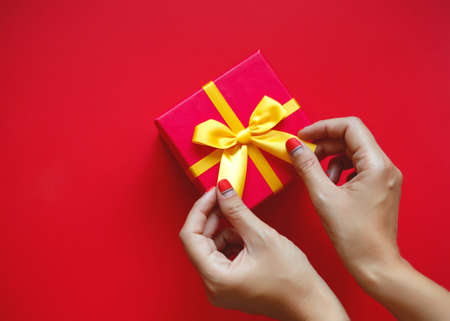 female hands with beautiful manicure hold a gift box.の写真素材