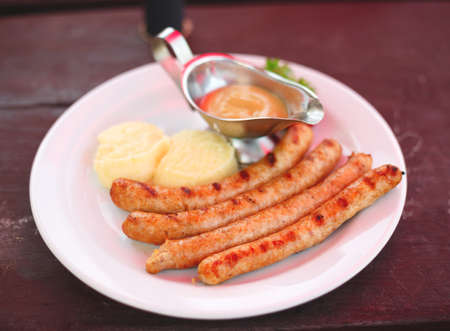 dish with bavarian sausages and mashed potatoes with sauces.の写真素材