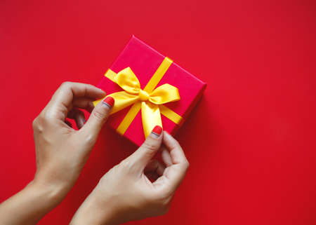 female hands with beautiful manicure hold a gift box.の写真素材