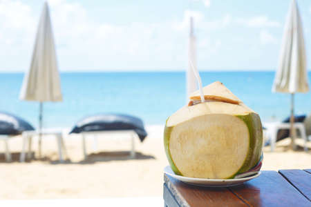 coconut on the table against the background of the sea and recreation area.の写真素材