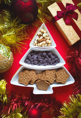 Christmas tree dish with nuts, chocolate and gingerbread cookiesの写真素材