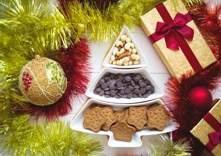 Christmas tree dish with nuts, chocolate and gingerbread cookiesの写真素材