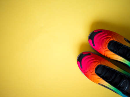 bright multicolored sneakers on a yellow background. flat layの写真素材