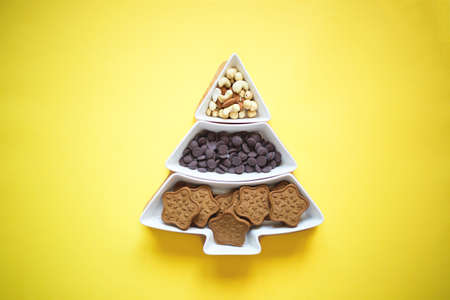 Christmas tree dish with nuts, chocolate and gingerbread cookies