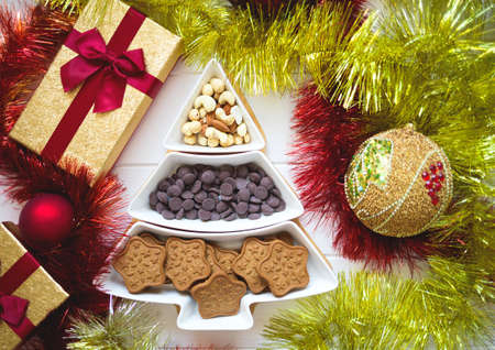 Christmas tree dish with nuts, chocolate and gingerbread cookiesの写真素材