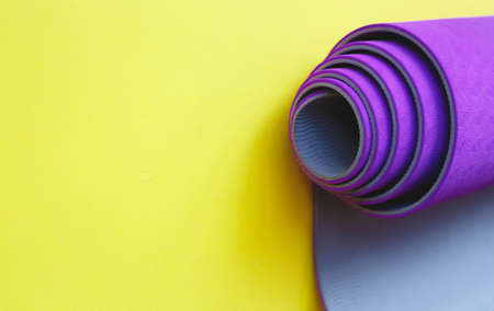 Bright purple yoga mat on a yellow backgroundの写真素材