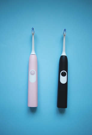 two ultrasonic electric toothbrushes on a blue background.の写真素材