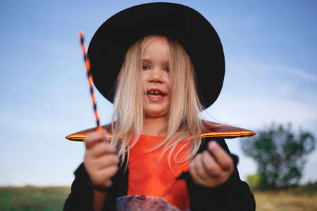 little girl dressed as a witch celebrates halloween.の写真素材