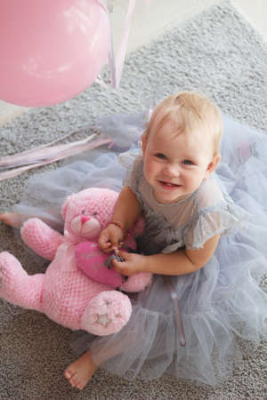 little girl is holding a teddy bear. selective focus, blurの写真素材