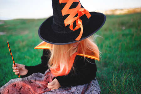 little girl dressed as a witch celebrates halloween.