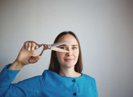 portrait of a young seamstress with scissors in her hands.の写真素材