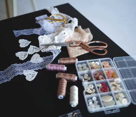 a stack of fabrics and sewing accessories on a tailor's table.の写真素材
