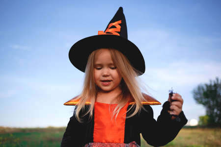 little girl dressed as a witch celebrates halloween.の写真素材