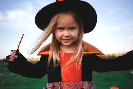 little girl dressed as a witch celebrates halloween.の写真素材