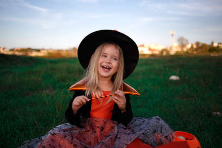 A little girl dressed as a witch celebrates Halloween.の写真素材