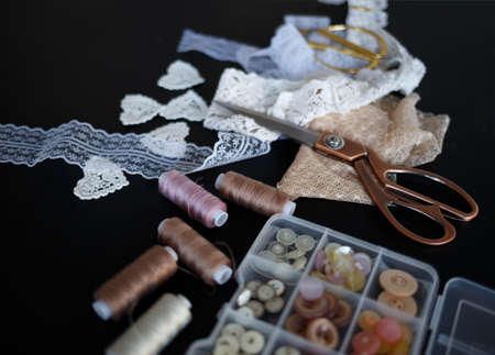a stack of fabrics and sewing accessories on a tailor's table.の写真素材
