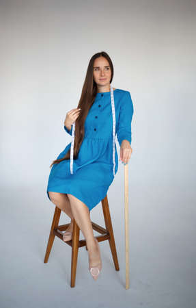 portrait of a young beautiful seamstress in blue dress.の写真素材