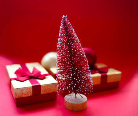 christmas tree and gifts on bright red background.の写真素材