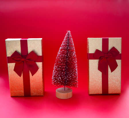 christmas tree and gifts on bright red background.の写真素材