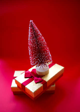 christmas tree and gifts on bright red background.の写真素材