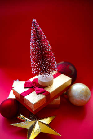 christmas tree and gifts on bright red background.の写真素材